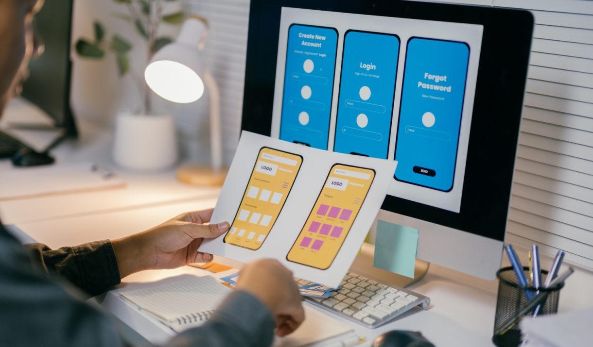 ux designer is reviewing paper prototypes of a mob nlr769m